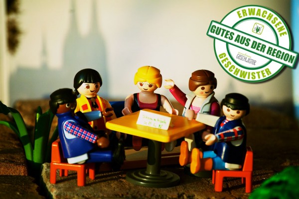 Figuren sitzen an einem Tisch